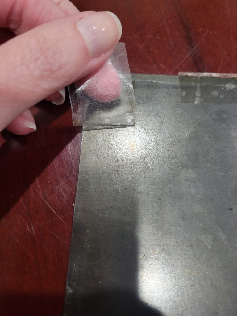 "Action shot" of slowly peeling the packing tape from the back of the photograph. This is not something you want to end up having to do!