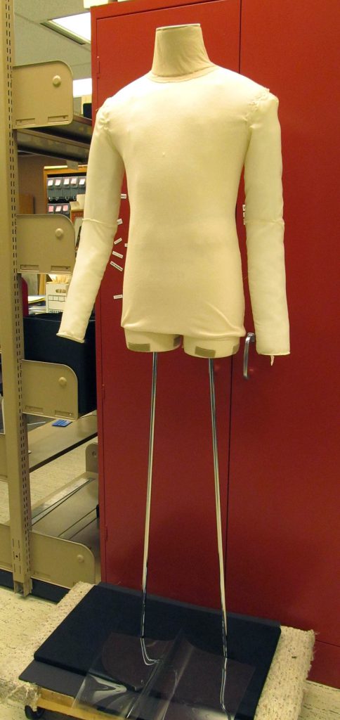 Here is a great example of padding done to a dress form to exhibit a WWI uniform. Notice how the sleeves have been added to the torso. This was done at the Ransom Center in Texas, and they have posted a fantastic step-by-step blog with photos of how they made this dress form work for their historic WWI uniform.