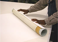 Here you can see staff at the National Archives rolling a historic document around a tube which will then be wrapped in acetate to be protected.