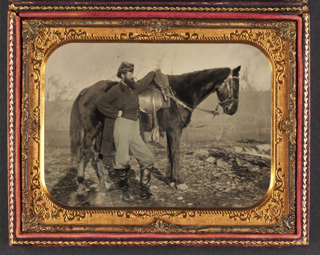 John E. Cummins of the 50th, 99th, and 185th Ohio Infantry regiments in Union uniform next to a horse